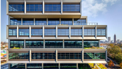 An image of a stack of rectangular office space under blue skies with many coworking offices inside. 