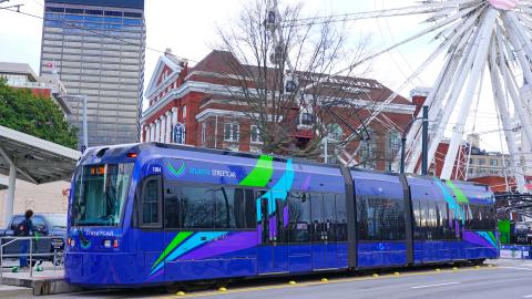 A long purple streetcar on the streets of Atlanta. 