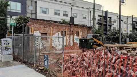 A pile of bricks and a bulldozer on an Atlanta Street. 
