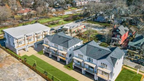 An aerial of new white homes for sale in a city. 
