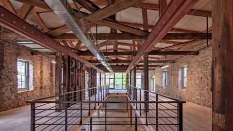 A view of an old mill converted to offices with stone walls. 