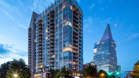 A photo of a glass and concrete high rise against evening skies in the Buckhead area of Atlanta. 