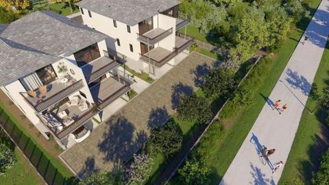 A rendering of two modern duplexes surrounded by trees next to a paved concrete trail. 