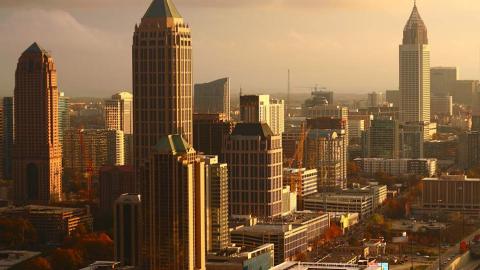 A photo of Atlanta's skyline in dimming orange light of evening. 