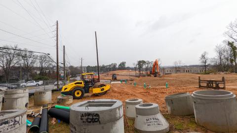 A photo of a large construction site under rainclouds in Atlanta with bulldozers nearby.