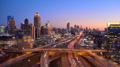 A photo of Atlanta's skyline in dimming orange light of evening. 