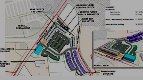 An image of a large development site next to a suburban sprawling mall with two big roads running through. 