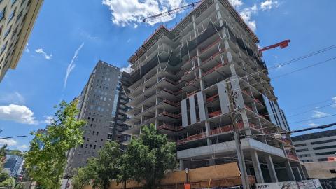 A photo of a large concrete building under construction in Atlanta under blue skies. 