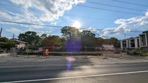 A photo of a construction site in Atlanta under blue skies, near a busy road. 