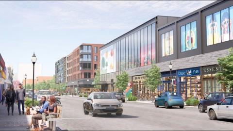 A rendering of a busy city street with a mall with many windows and shops at left, under blue skies.