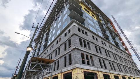 A tall new concrete building under grey skies where condos will be built in Atlanta. 