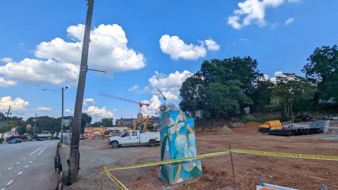 A construction site for a fast food restaurant in Atlanta, with red dirt under blue skies and a white truck in the middle distance.