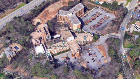 An image of two larger old brick apartment complexes standing next to busy roadways in Atlanta.