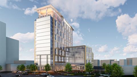 A rendering of a medical facility tower under blue skies behind a busy Atlanta street.