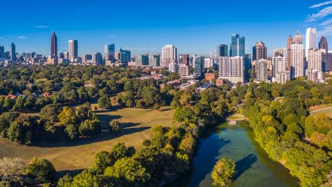 A skyline photo of Atlanta and a huge park under blue skies. 