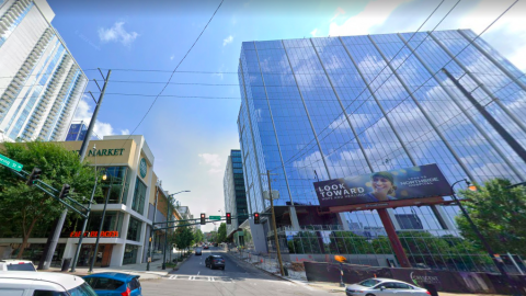 A photo with two glassy high-rises under blue skies in Atlanta near a busy street.