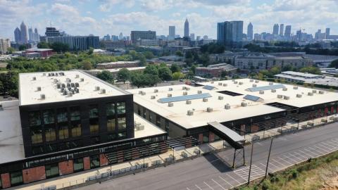 A photo of a former warehouse turned into a shopping and dining complex with Atlanta's skyline in the distance.