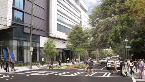 A busy street shown in a rendering with a new bike lane near many trees in Atlanta. 