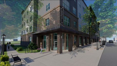 A rendering of a new building with brick and stucco near large sidewalks with trees all around it.