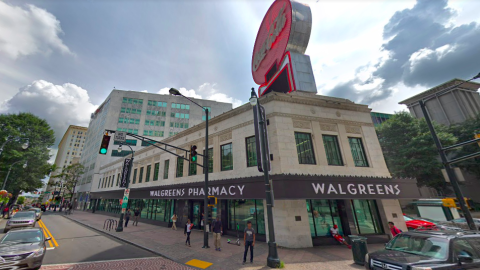 A photo of a long low white building with a red Coke sign in lights atop it, in downtown Atlanta. 