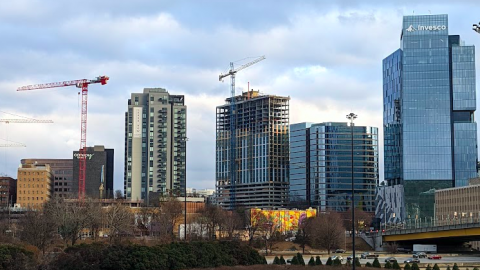 A photo of a topped out new apartment tower under blue-gray skies in Atlanta. 