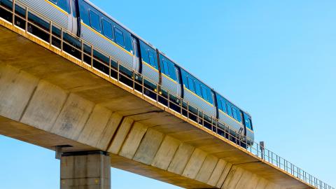 A photo of a MARTA train in Atlanta under blue skies on elevated tracks. 