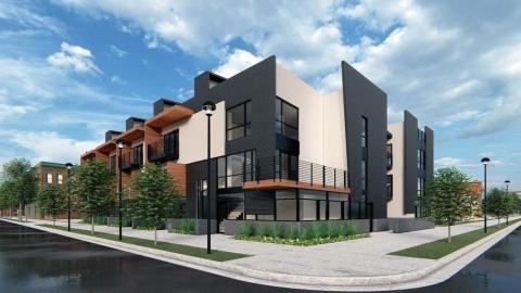 An image of a corner site in Atlanta under blue skies with modern townhomes on it.