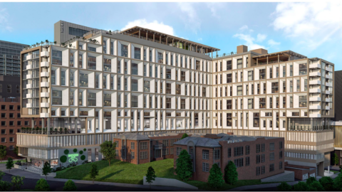 A rendering showing a long white L-shaped building with many balconies under blue skies next to brick apartments. 