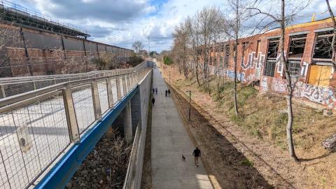 A photo of a large brick building next to a wide street and also a big walking path under blue cloudy skies in Atlanta.