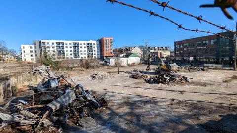 A huge development site under blue skies in Atlanta with much rubble and scrap on concrete.