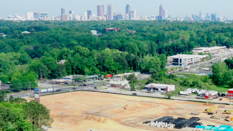 An aerial photo of a large construction site where a shopping center has been demolished beside two busy roads.