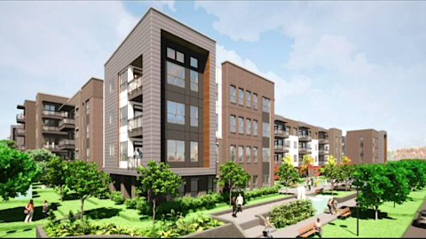 An image showing a new modern-style brick and stucco apartment building under blue skies in Atlanta.