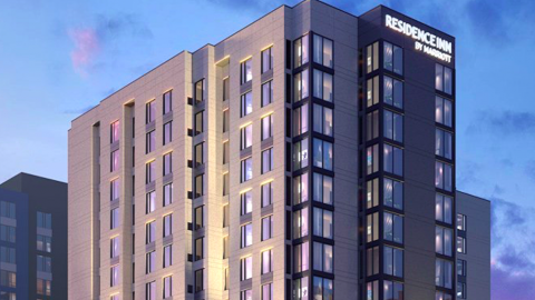 An image showing plans for a new glass and stucco hotel under blue-purple skies in Atlanta, Georgia. 