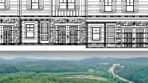 An image showing a site where rows of two-story townhomes are being built with many mountains in the background.