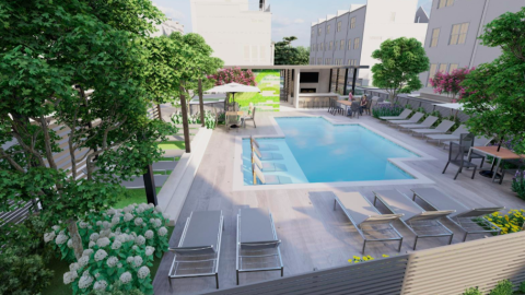 A Morningside townhome development with a pool surrounded by many tall buildings under blue skies with trees planted around in Atlanta.