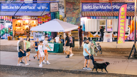 A wide walking trail with small businesses beside it built from shipping containers in Atlanta.