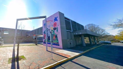 An image of a MARTA train station in Atlanta made of concrete near a large lot under blue skies.