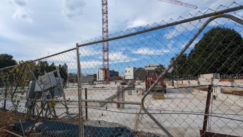 A photo of a large construction site with a concrete base under blue skies and a crane in Atlanta.