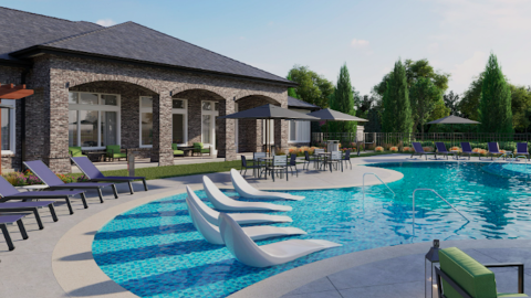 An image of a low-rise apartment complex with a pool and large gym situated near many trees under blue skies.