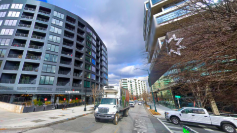 A photo of a crowded street in Atlanta with many cars and people in crosswalks.