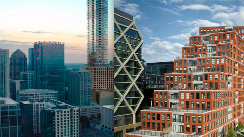 An image of a city with several tall buildings under blue skies near wide streets. 