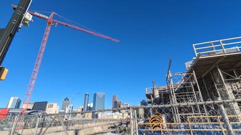 A photo of a large construction site in downtown Atlanta under blue skies near two wide streets.