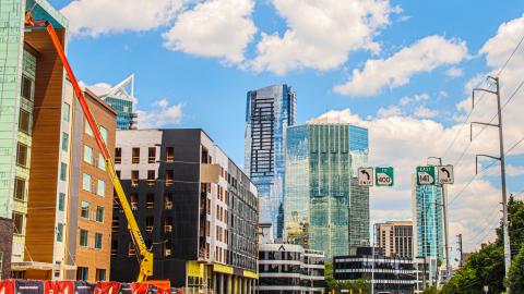 A photo of a city under a blue sky next to a large building under construction. 