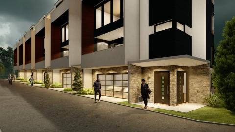 An image showing a site where modern white black and wood townhomes are expected to rise under gray skies next to a wide street.