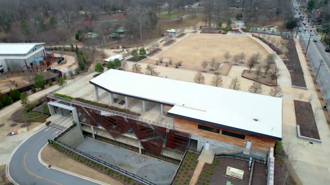 An aerial photo of a large modern restaurant space next to a park in Atlanta, beside a wide road.