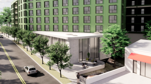 An image showing a site for a large green new apartment building with a lobby and amenities area in front along a bending road in Atlanta. 