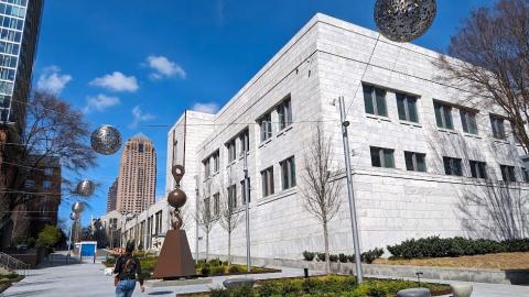 A photo of a new art plaza under blue skies near many tall buildings in Atlatna, with seating and plants added. 