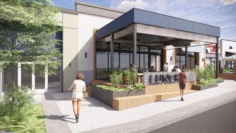 An image showing a remade shopping center under blue skies around a large parking lot in Buckhead Atlanta.