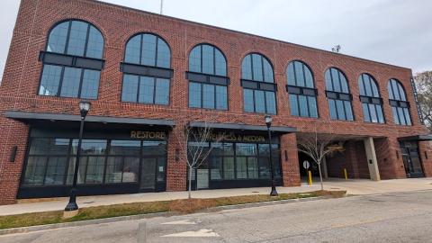 An image of a large brick boutique building under gray skies in Atlanta. 