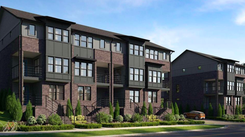 An image of a townhome build under blue skies near a wide highway and many trees in Atlanta. 